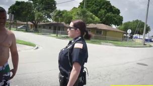 Two busty police officers in outdoor act with black dude