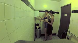 Two harlots are in the public bathroom, licking one some other